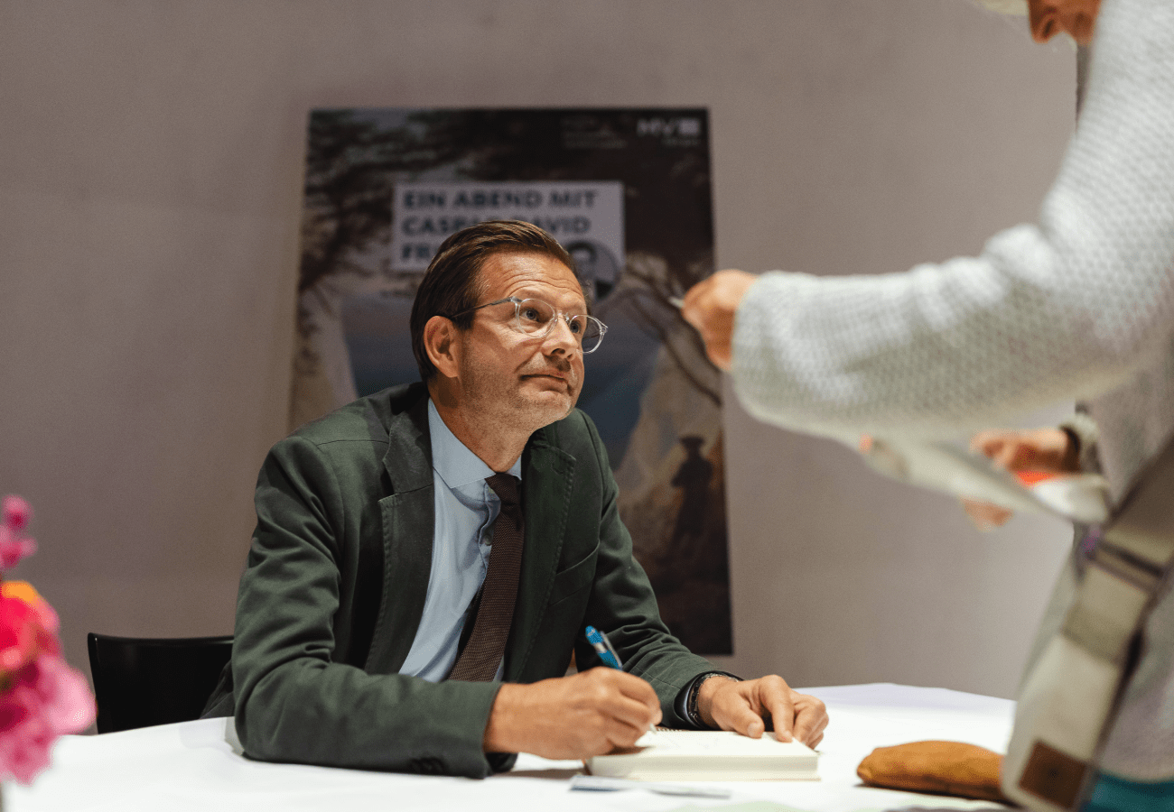 Bestsellerautor Florian Illies signiert sein Werk für interessierte Besucher:innen.