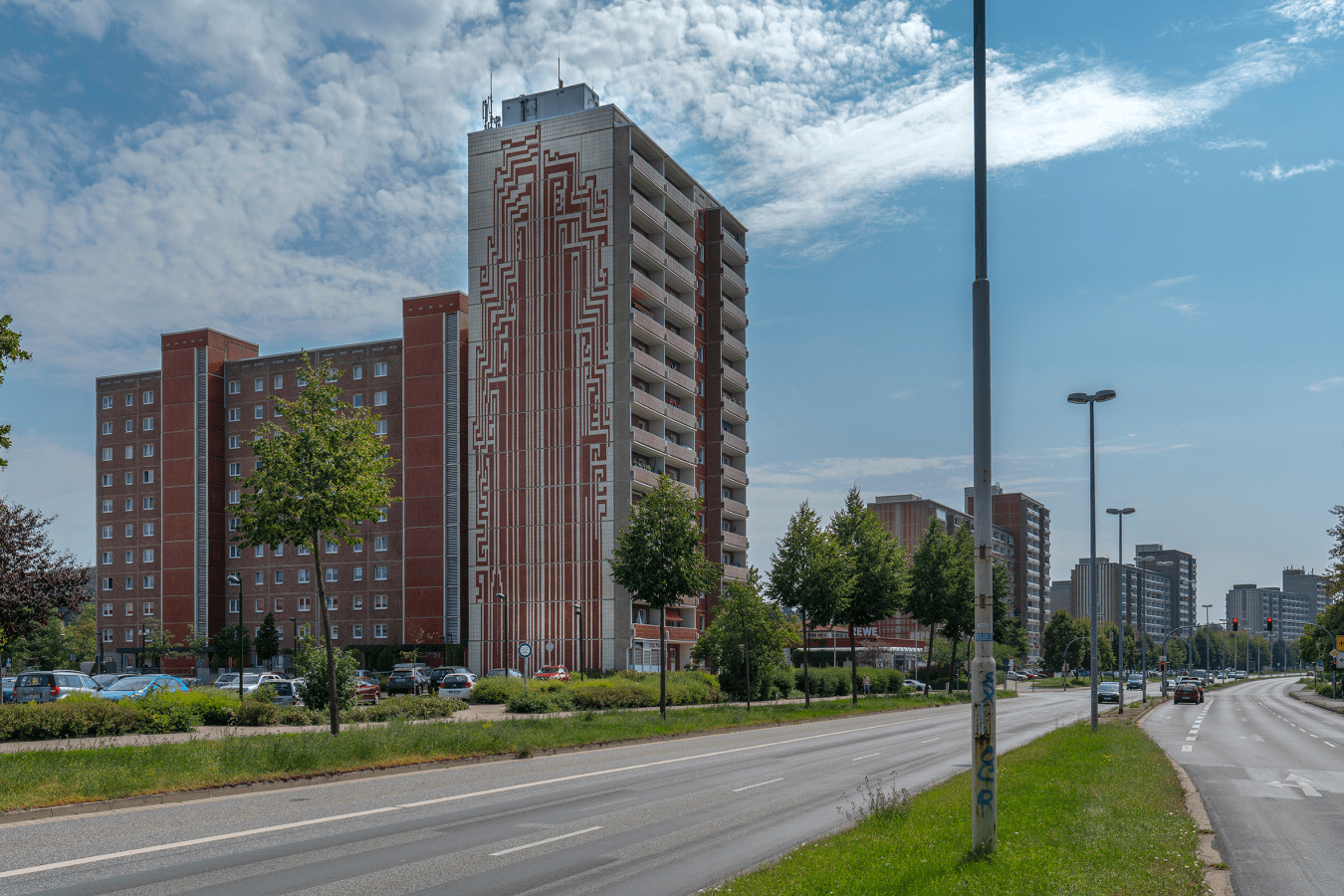Das Wandbild „Die Quelle“ von Wolfram Schubert an einem 14-geschossigen Hochhaus in der Neustrelitzer Straße (Südstadt Neubrandenburg), einem von 15 Gebäuden des Plattenbautyps WBS 70, die als Zeugnis der Sozialpolitik der DDR, in Neubrandenburg historisch wertvoll und schützenswert sind. Die Anfang der 1980er Jahre entstandenen Hochhäuser mit 1100 Wohnungen sind im Gegensatz zu anderen Städten in der Grundsubstanz ursprünglich erhalten. © Achim Bötefür (2019) Das Wandbild „Die Quelle“ von Wolfram Schubert an einem 14-geschossigen Hochhaus in der Neustrelitzer Straße (Südstadt Neubrandenburg), einem von 15 Gebäuden des Plattenbautyps WBS 70, die als Zeugnis der Sozialpolitik der DDR, in Neubrandenburg historisch wertvoll und schützenswert sind. Die Anfang der 1980er Jahre entstandenen Hochhäuser mit 1100 Wohnungen sind im Gegensatz zu anderen Städten in der Grundsubstanz ursprünglich erhalten.